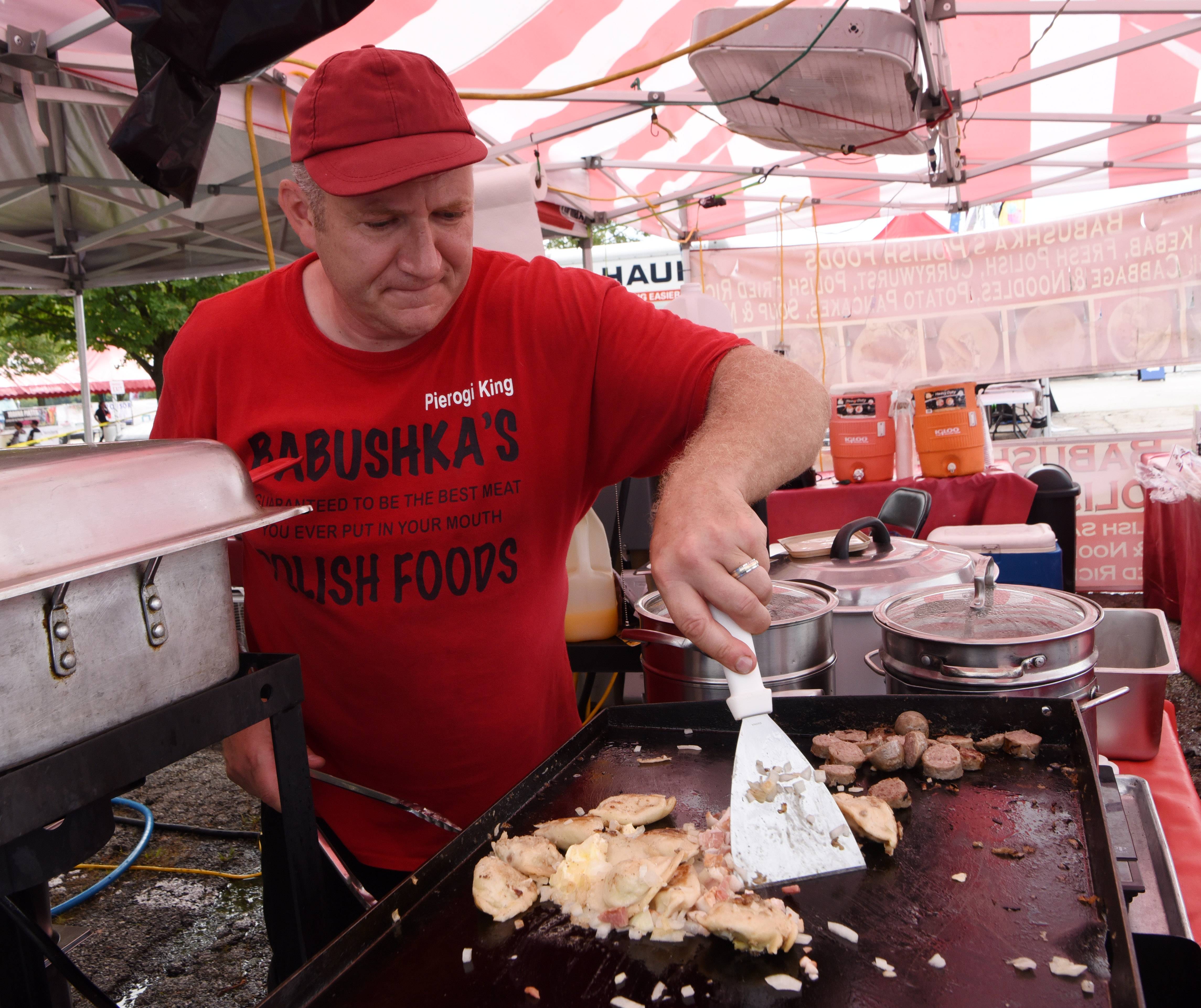 Dominic Babushka of Babushka's Polish Foods prepares pierogies, sausage, bacon and onions during Festival Polonaise at Arlington Park in Arlington Heights Saturday.