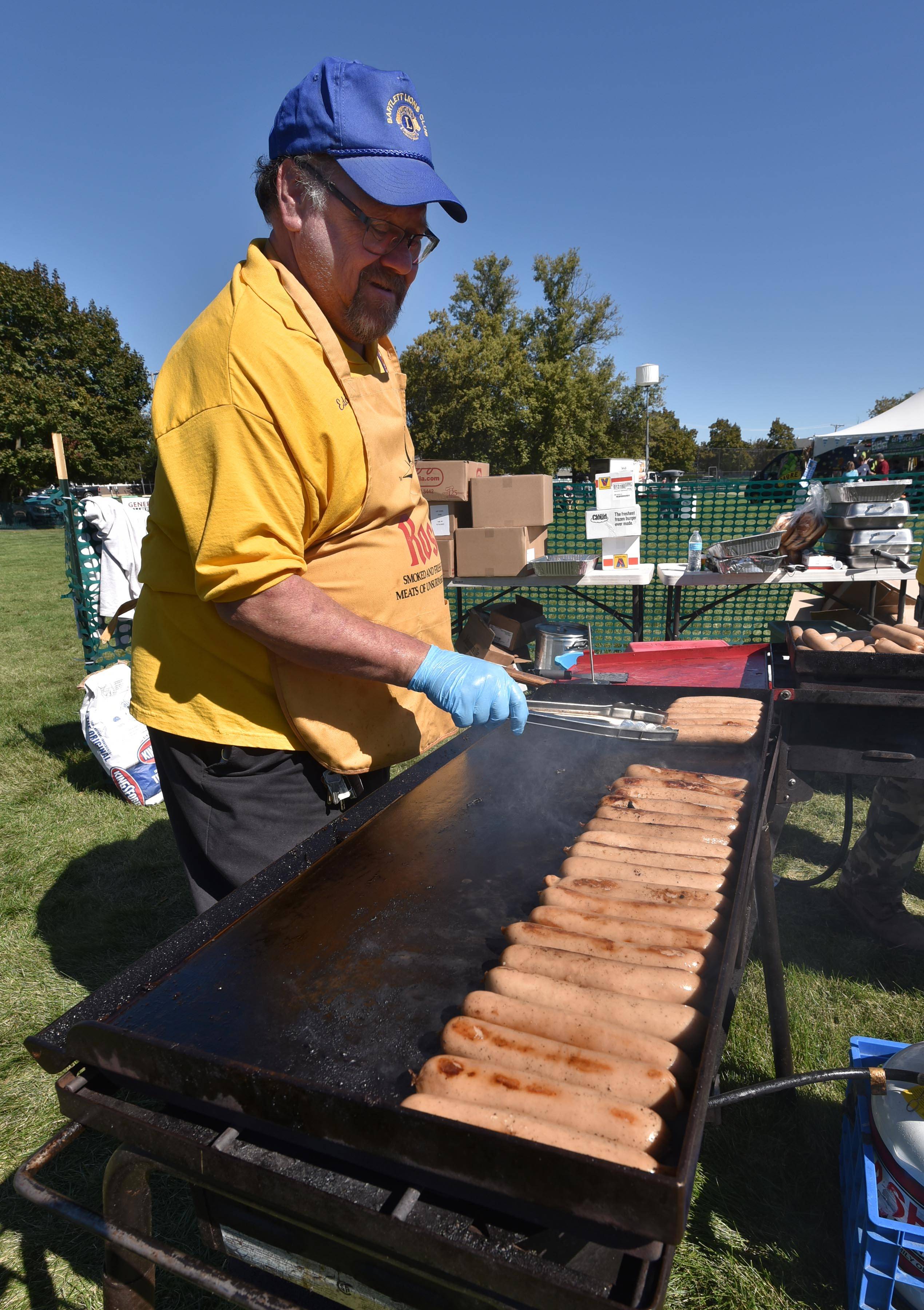 Ed Raska, of the Bartlett Lions Club, grills bratwurst at the Bartlett Area Chamber Oktoberfest at Leiseburg Park on Saturday.